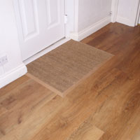 Karndean flooring fitted throughout hallway into bathroom, with coir matting fitted to the right of picture.